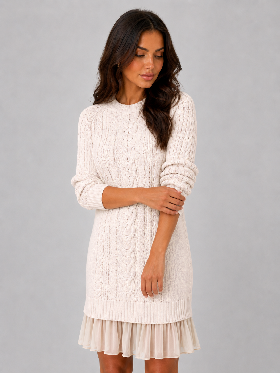 Women's cream cable knit mini dress with pleated hem, angled front view