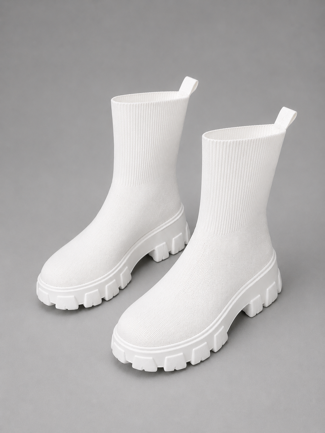 White women's stretch sock boots with a ribbed upper and chunky sole.